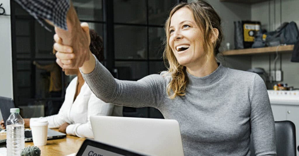 Handshake between business professionals in a modern office setting promoting networking and collaboration.