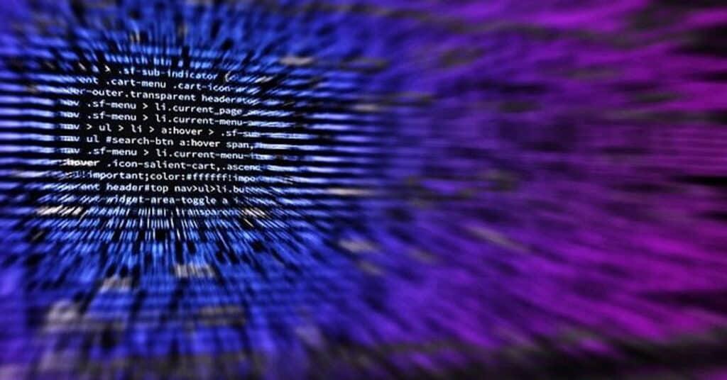 Code snippet on a digital screen with vibrant purple and blue background, representing cybersecurity and technology management.